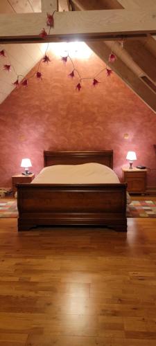 - une chambre avec un lit orné de fleurs sur le mur dans l'établissement La Longère des Noëls, à Vineuil