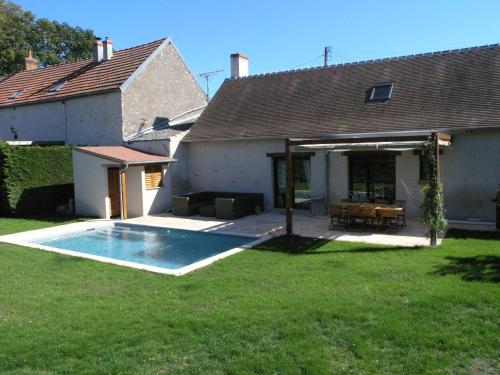 une cour arrière avec une piscine et une maison dans l'établissement La Longère des Noëls, à Vineuil