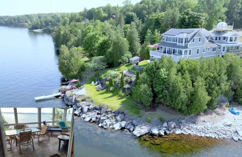 an aerial view of a large house on an island in the water at Loza house adirondack screened-in porch unit lake front in Plattsburgh