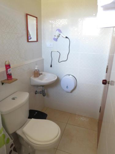 ein Badezimmer mit einem weißen WC und einem Waschbecken in der Unterkunft Hotel Casita de Belén in Sonsón