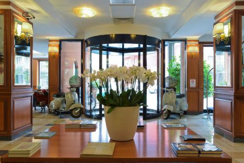 a lobby with a vase of flowers on a table at Grand Hotel Tiberio in Rome