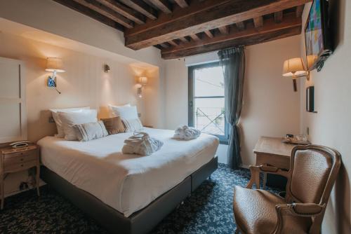 ein Schlafzimmer mit einem großen Bett und einem Fenster in der Unterkunft Hôtel Henry II Beaune Centre in Beaune