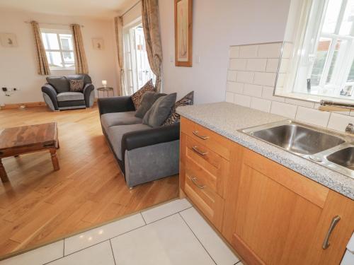 a kitchen and living room with a couch and a sink at 2 Carlton Cottage in Enniskillen