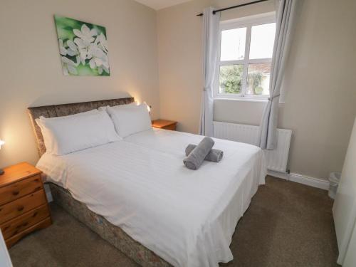 a bedroom with a bed with a teddy bear on it at 2 Carlton Cottage in Enniskillen