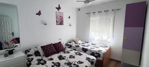 1 dormitorio con 2 camas y mariposas en la pared en Casa Marina, en Moraira
