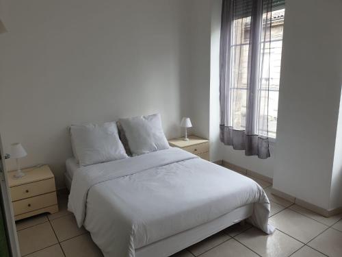une chambre avec un lit blanc et une fenêtre dans l'établissement Maison 150m2 jardin à louer en entier, Bordeaux centre Chartrons, 3 Chambres 3 Salles de bains 1 canapé-lit llllnuméro de téléphone dans l'annonce si questionlll, à Bordeaux
