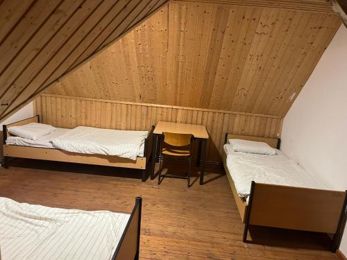 a room with two beds and a table and a chair at Waldschlösschen Ricklingen in Hannover