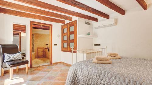 a bedroom with a bed and a chair in a room at Can Williams in Pollença