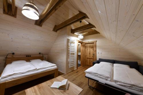 a bedroom with two beds in a wooden room at Tri borovice in Liptovský Mikuláš