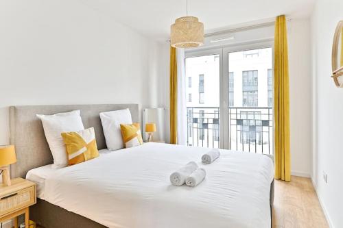 une chambre avec un grand lit avec deux serviettes dessus dans l'établissement Appartement 3 Chambres Mairie Saint-Ouen, à Saint-Ouen