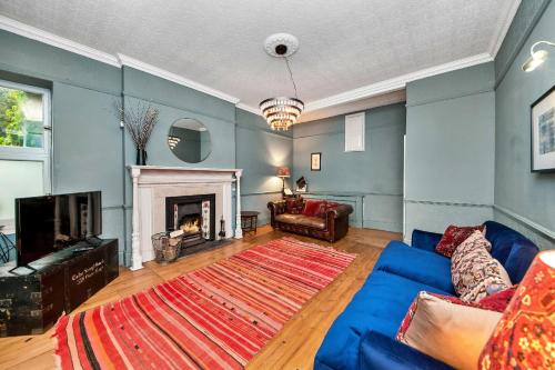 a living room with a blue couch and a fireplace at Finest Retreats - Low Green Cottage in Catterick Bridge