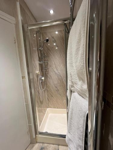 a shower with a glass door in a bathroom at Shemara rooms in Keswick