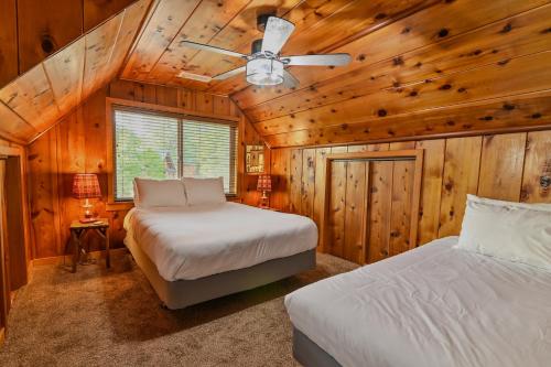 a bedroom with two beds and a ceiling fan at Harris Lakeview Cabin in Bass Lake