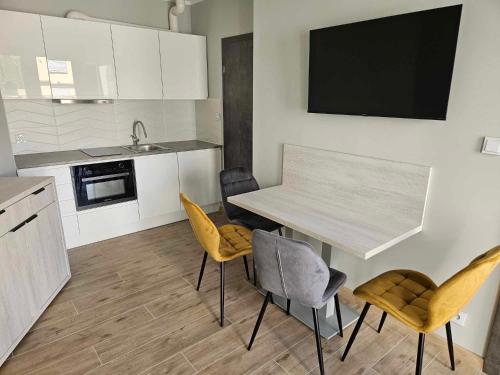 ジブヌフにあるApartamenty Dziwnów Welleのキッチン(テーブル、椅子、シンク付)