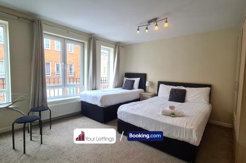 um quarto de hotel com duas camas e uma janela em Luxury 6 Bedroom Contractor House By Your Lettings Short Lets & Serviced Accommodation Peterborough With Free WiFi em Peterborough