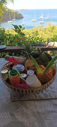 ein Korb mit Essen auf einem Tisch mit Blick auf das Meer in der Unterkunft TI KAZ ANOLI Cottage en bois avec vue sur la baie in Terre-de-Bas