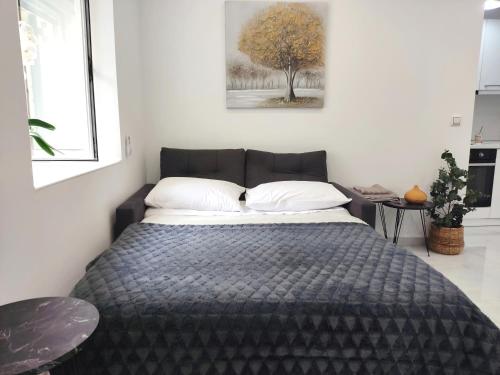 a bedroom with a bed with a tree on the wall at Lusso di Campiello in Corfu Town