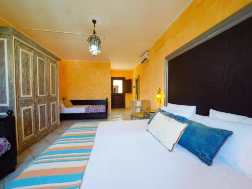 1 dormitorio con 1 cama blanca grande con almohadas azules en Chiusurelle Village Resort, en Punta Prosciutto