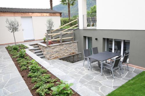 a patio with a table and chairs next to a building at Casa QUATTRO FIUMI in Tegna