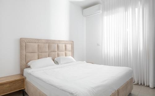 - une chambre avec un grand lit et des draps blancs dans l'établissement Oren Eilat Amazing 4 bedrooms house with sea view, à Eilat