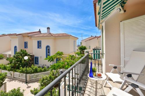 a balcony of a house with white chairs at Marina Port 15 by VillaGranCanaria in Pasito Blanco