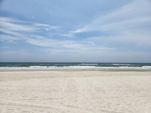 a sandy beach with the ocean in the background at Condo in Gulf Shores King Suite in Gulf Shores