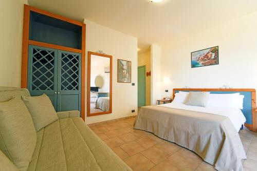 um quarto com uma cama grande e um sofá em Futura Club Itaca Nausicaa em Rossano