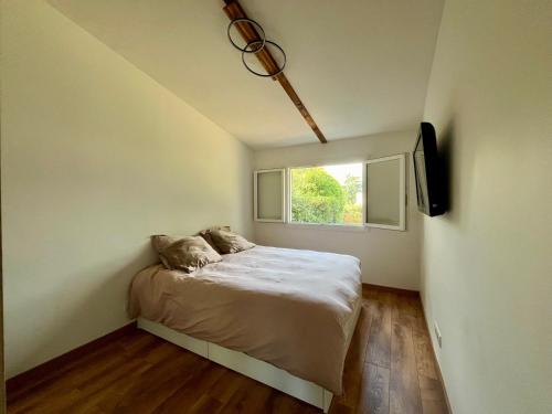 une chambre avec un lit et une fenêtre dans l'établissement Coup de cœur charmante maison aux bois murés, à Grasse