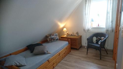 ein Schlafzimmer mit einem Bett, einem Stuhl und einem Schreibtisch in der Unterkunft Haus Shanty in Boren