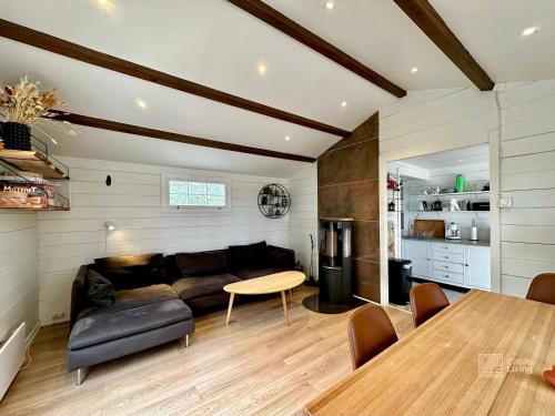 een woonkamer met een bank en een tafel bij Summer cabin in Nesodden open-air bath large terrace in Brevik