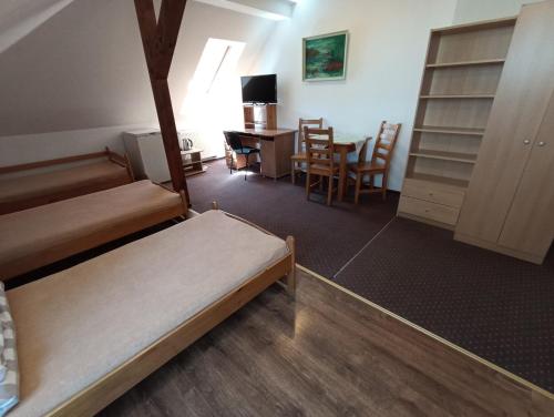 マルボルクにあるDom Turysty Na Skarpieのベッド2台、デスク、テーブルが備わる客室です。