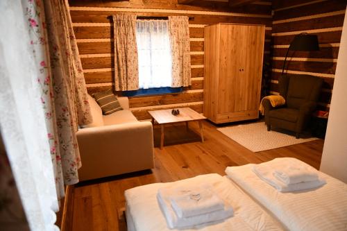 a room with two beds and a chair and a window at Tri borovice in Liptovský Mikuláš