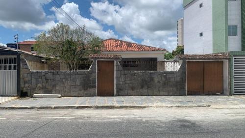 uma cerca de pedra com duas portas e um edifício em Ampla e Aconchegante Casa no Bairro da Liberdade na Cidade de Campina Grande Pb em Campina Grande
