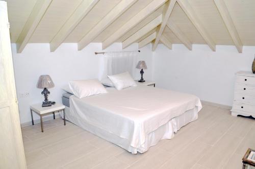 a bedroom with a white bed and two night stands at Villa Aristoteles in Halki