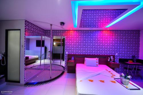 a bedroom with pink and purple lights on the wall at MOTEL LA FOLIA in Ribeirão Preto