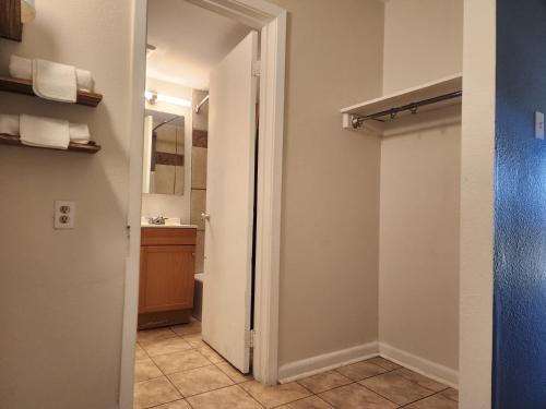 a bathroom with a door leading to a bathroom with a sink at Red Carpet Inn - Houma in Houma