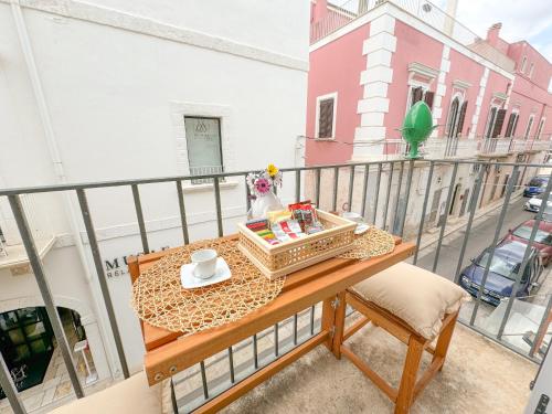 a balcony with a table with a tray of food on it at Vingt Sept in Polignano a Mare