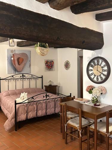 a bedroom with a bed and a table and a clock at La Tana del Grillo in Pitigliano