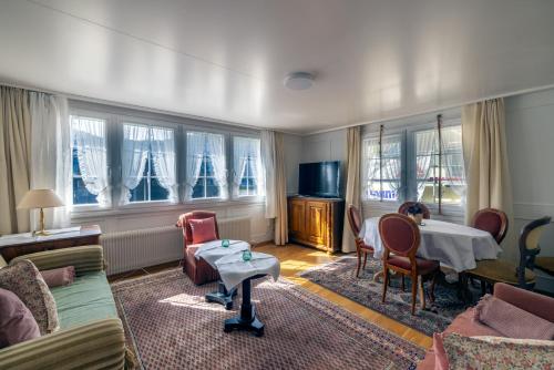 a living room with a table and chairs and windows at Blattenheimat6 - im traditionellen Appenzeller Haus in Appenzell