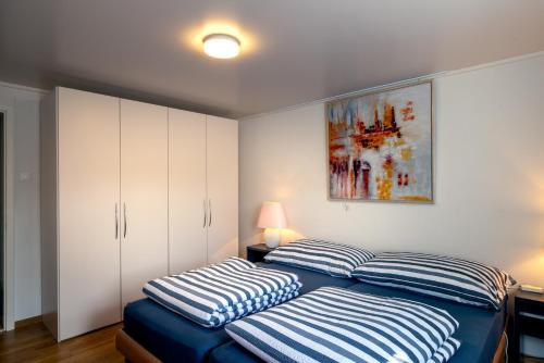 a bedroom with a bed with striped pillows on it at Blattenheimat6 - im traditionellen Appenzeller Haus in Appenzell