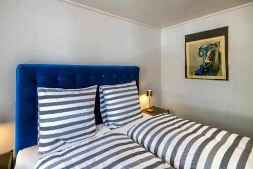 a bedroom with a blue headboard and two striped pillows at Blattenheimat6 - im traditionellen Appenzeller Haus in Appenzell