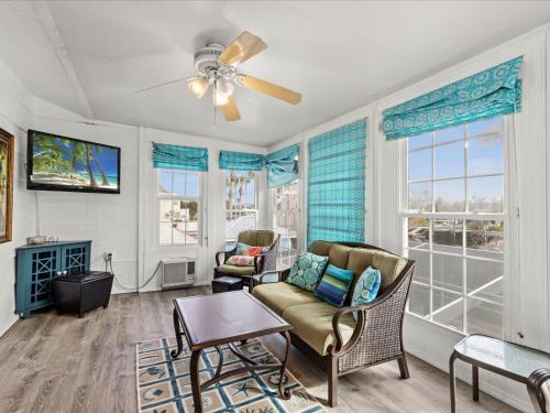 a living room with a couch and chairs and windows at *NEW* POOL screened-in, Waterfront, 4 Kayaks, Pet in Hernando Beach