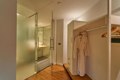 a dressing room with a robe hanging on a glass door at New President Hotel Cairo in Cairo