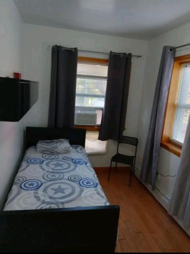 een kleine slaapkamer met een bed en een raam bij Comfortable rooms in NYC near the train in Woodside