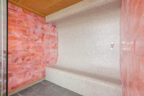 a bathroom with a red brick wall at Demelza in Helston