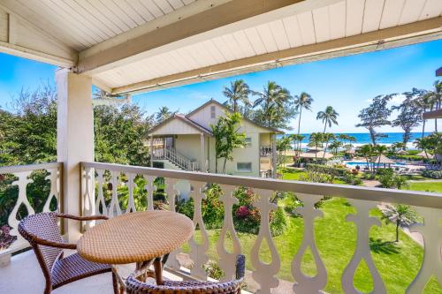 a balcony with a table and chairs and a view of the ocean at Islander on the Beach 309 - Studio in Kapaa