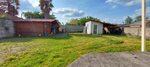 une cour avec une maison et un hangar dans l'établissement Maison individuelle avec jardin, au calme, à Lorp Sentaraille