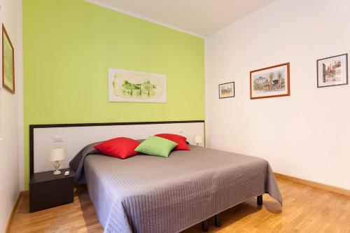 ローマにあるCasa Vacanze "Sognando Roma"のベッドルーム1室(赤と緑の枕2つ付)