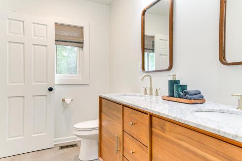 a bathroom with a sink and a toilet and a mirror at Palmetto Cottage with Fire Pit, Game Table and More! in Fairburn