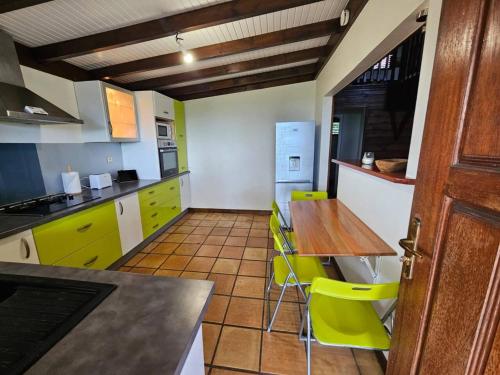 eine Küche mit einem Holztisch und grünen Stühlen in der Unterkunft Maison de 3 chambres avec sauna terrasse et wifi a Ducos in Ducos